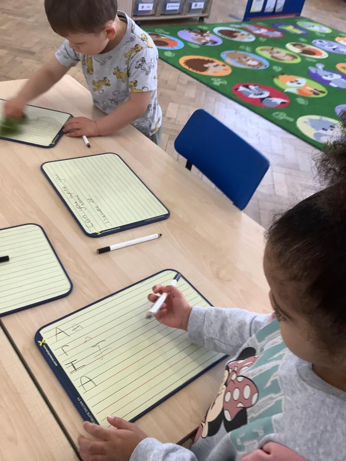 Toddlers exploring sensory play with water and sand trays